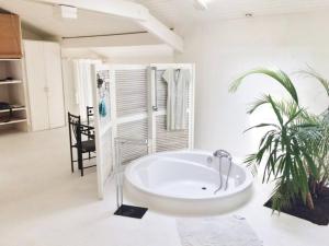 卡布勒通BRUYERES - Capbreton, belle villa spacieuse entre ville et plages au calme的一间白色的大浴室,配有浴缸和棕榈树