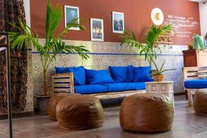 达喀尔卡萨玛拉达喀尔酒店的客厅配有蓝色沙发和一些植物
