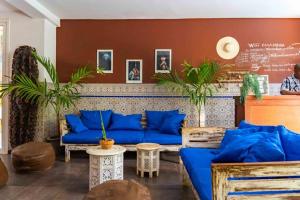 达喀尔卡萨玛拉达喀尔酒店的客厅配有蓝色的沙发和植物