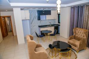 杜阿拉Geneva Hotel的厨房以及带桌椅的起居室。