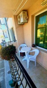 普里莫尔斯科Guest House Natali的阳台配有两把椅子和一张桌子,还有一个窗户。