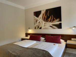 Oberaurach兰德奥博浪可酒店的一间卧室设有两张床,墙上挂着一幅画