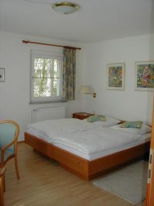 巴特萨罗皮斯库夫Haus Waldfrieden的卧室配有床、椅子和窗户。