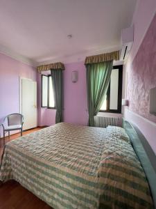 巴尼奥雷焦Hotel divino Amore的一间卧室设有一张大床,拥有紫色的墙壁和窗户