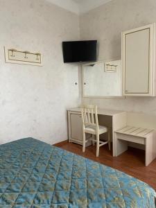 巴尼奥雷焦Hotel divino Amore的一间卧室配有书桌、一张床和一台电脑