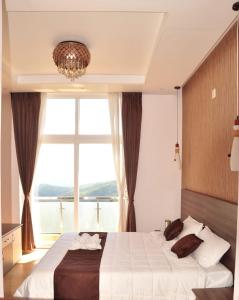 乌提Vanam Holidays Inn的一间卧室设有一张大床和大窗户