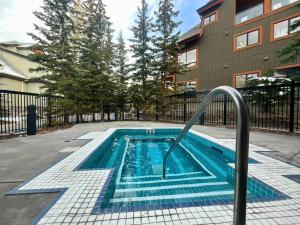 坎莫尔Fenwick Vacation Rentals Suites with Pool & Hot tubs的一座游泳池,旁边是一座建筑物,上面有金属栏杆