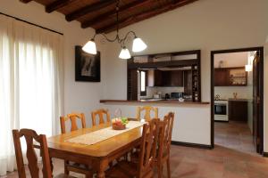 门多萨Casa Agostino - Luxury wine and hotel in Bodega Agostino的厨房以及带木桌和椅子的用餐室。