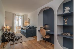 里斯本Ando Living - Santa Justa 77 Flats的客厅配有蓝色的沙发和椅子