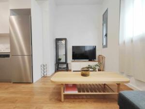 马塔罗Mazi Apartments Loft的客厅配有桌子和冰箱