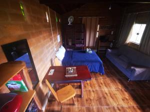 戈亚斯州上帕莱索Chalé Astral的客厅配有床和桌子