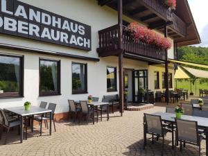 Oberaurach兰德奥博浪可酒店的大楼前设有桌椅的餐厅