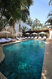 卡塔赫纳卡萨佩斯塔瓜雷莱斯城堡酒店的度假村的游泳池配有椅子和遮阳伞