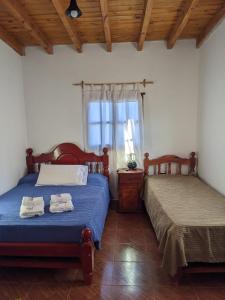 卡奇Lo de Valentino Cabaña的一间卧室设有两张床和窗户。