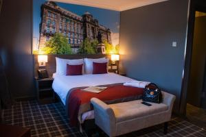 格拉斯哥Devoncove Hotel Glasgow City的酒店客房设有一张大床,还有一座大型建筑