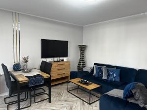 PogórzeApartament Elisabeth BLUE I的客厅配有蓝色的沙发和电视