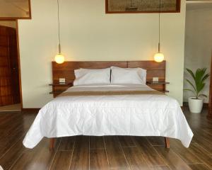 SauceRiosol Hotel Laguna Azul的卧室配有一张带两个灯的大白色床