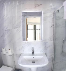 布莱克浦Blackpool Resort Hotel的白色的浴室设有水槽和镜子