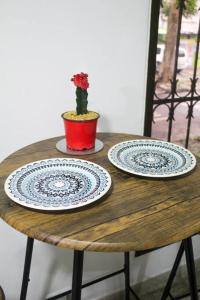 麦德林Aparta- estudio Ziruma 102的木桌上两盘,有植物
