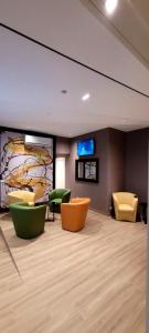 卡塔尼亚Th Luxury Central的一间设有绿色和橙色椅子和墙壁的等候室