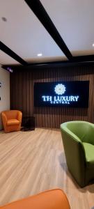 卡塔尼亚Th Luxury Central的大堂墙上有标志,配有绿椅