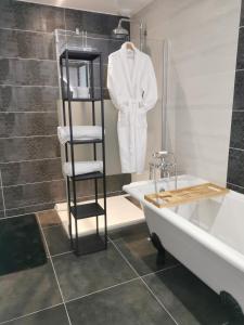 Sainte-Croix-sur-MerChambre de l'Iris的浴室设有白色的衣服架子和浴缸。