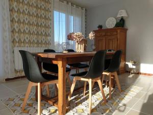 La petite ferlicaine的木制餐桌,配有黑色椅子和桌子