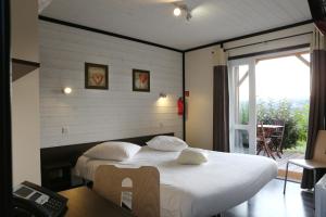 米洛多梅茵圣埃斯泰夫酒店的一间卧室配有带枕头的床