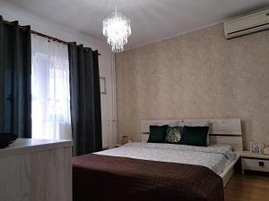 康斯坦察Relax Apartament的一间卧室配有一张大床和一个吊灯。