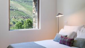 阿利若Quinta de Merouço - Villa do Rolapipas的一间卧室设有一张床和一个美景窗户。
