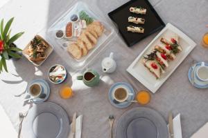 阿克罗蒂里Arcana Santorini Villas, An Authentic Cycladic Experience的餐桌,盘子上放着食物和咖啡