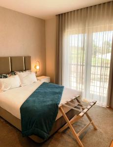 查韦斯阿尔贝加博尔赫斯酒店的一间卧室设有一张大床和一个大窗户