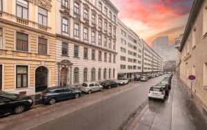 维也纳MALIXA - Apartment in the heart of Vienna next to Metro的一条城市街道,有停车的汽车和建筑