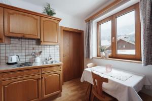 莱奥冈Appartement Leni Leogang的厨房配有桌子、水槽和窗户