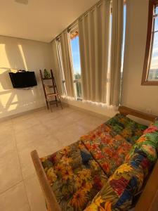 圣湖镇Casa da Vista - LAGOA SANTA的客厅配有带花毯的沙发