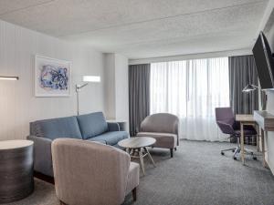 印第安纳波利斯Crowne Plaza Indianapolis-Airport, an IHG Hotel的客厅配有蓝色的沙发和椅子
