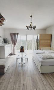 GudciHouse with hot tub, sauna and swimming pool near Zagreb的一间卧室配有两张床、一张桌子和一个吊灯。