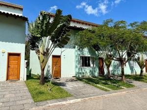 圣塞巴斯蒂安Casa Clean e Comfort, a mais completa de Paúba的两扇棕色门和一些树木的房子