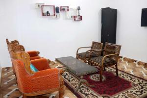 克久拉霍Khajuraho Glory Homestay的客厅配有三把椅子和一张桌子