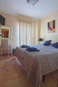韦尔瓦Apartment Isla Canela Luxury的一间卧室配有一张大床和一张书桌