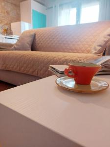 卡斯德尔诺沃贝拉登卡La casa di Elvira2的一张桌子上的红咖啡杯,沙发上
