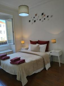 里斯本Bird's Nest Lisbon Apartment的一间卧室配有一张大床和毛巾