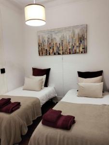里斯本Bird's Nest Lisbon Apartment的墙上画画的房间里设有两张床