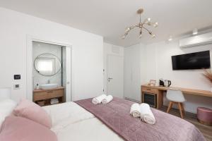 扎达尔Aura Exclusive Apartment & Room的一间卧室配有床、水槽和镜子