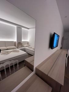 格勒姆Best summer Apartment的一间卧室设有两张床,墙上配有电视。