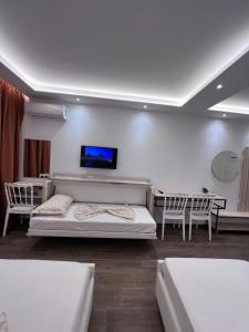 格勒姆Best summer Apartment的客房设有两张床和一台墙上的电视。