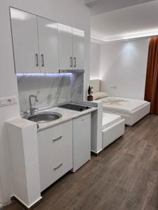 格勒姆Best summer Apartment的白色的厨房配有水槽和床