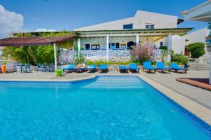 威利布罗德自然库拉索公寓式酒店的一个带蓝色椅子的游泳池