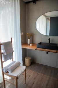 圣克鲁兹Vibo Wine Lodge At Viu Manent的浴室设有水槽、椅子和镜子