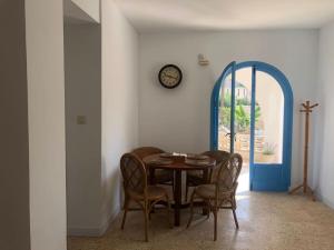 皮莱斯Villa Azul Beach的一间带桌椅和时钟的用餐室